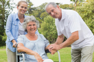 Smiling woman in wheelchair with daughter and husband.